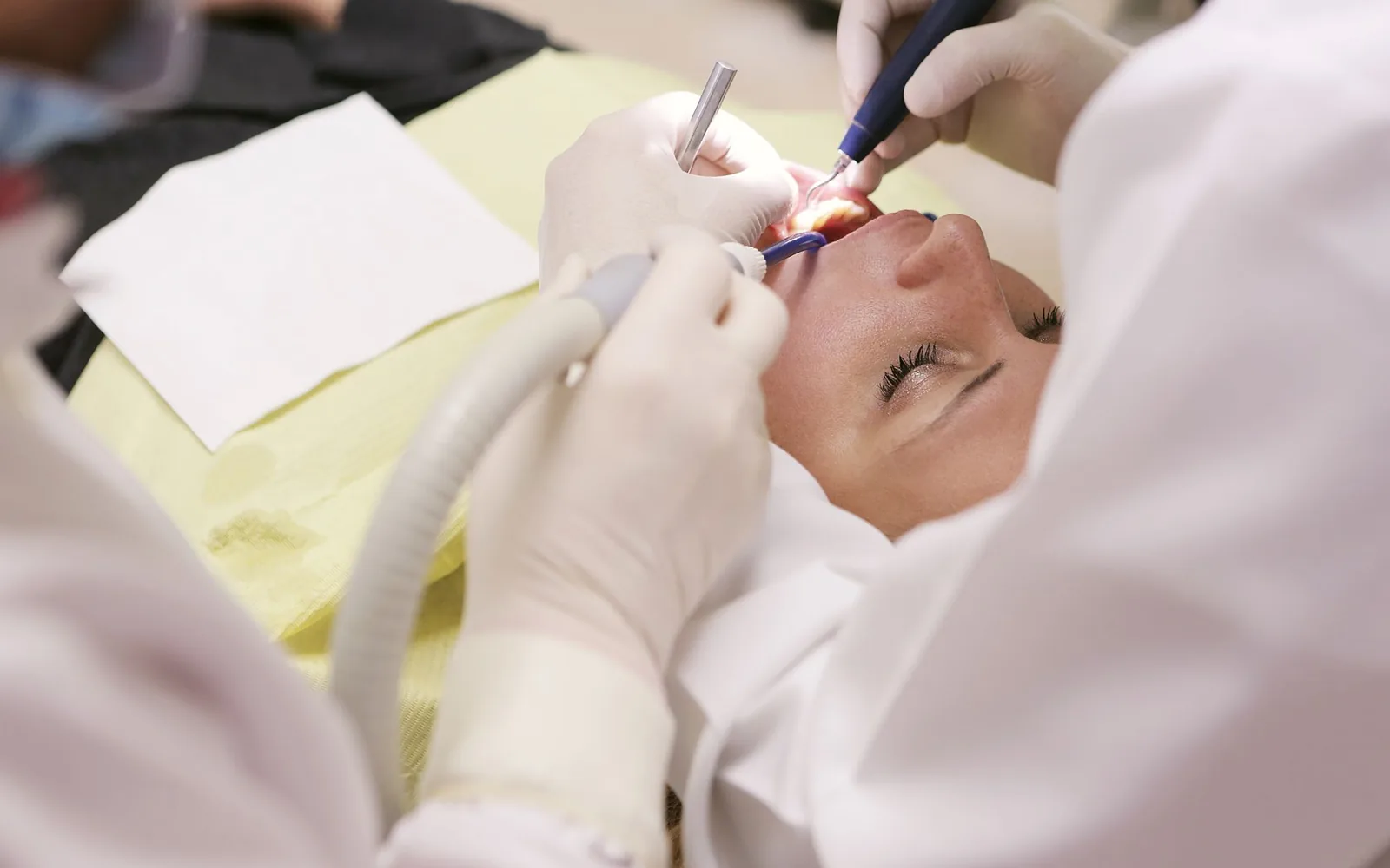 Dentista examinando paciente em consultório odontológico